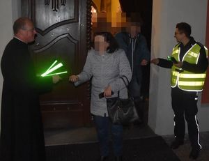 wyjście z kościoła ksiądz z policjantami rozdaje odblaski